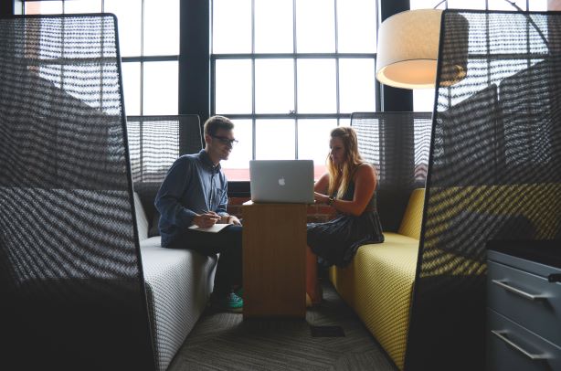 Two people sitting together doing work