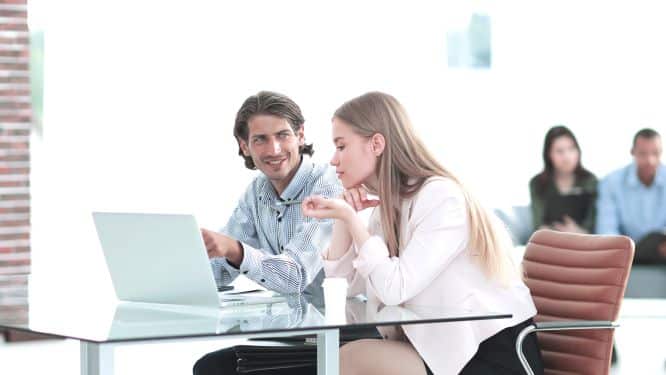 Man smiling at a woman in a meeting