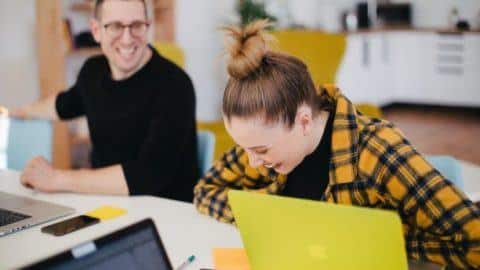 A woman laughing with a team member