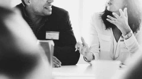 Two people talking at a desk