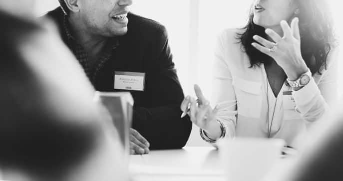 Two people talking at a desk