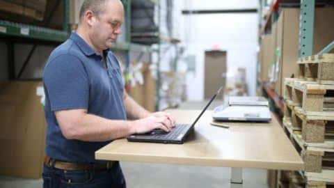 Man working at a desk in a warehouse